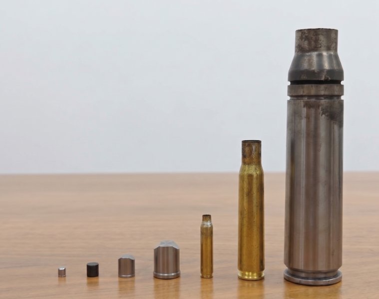 A row of tested projectiles in ascending size, from small fragments up to a heavy-caliber round