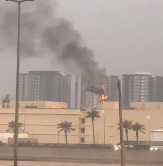 A strike impact and smoke plume near an urban installation